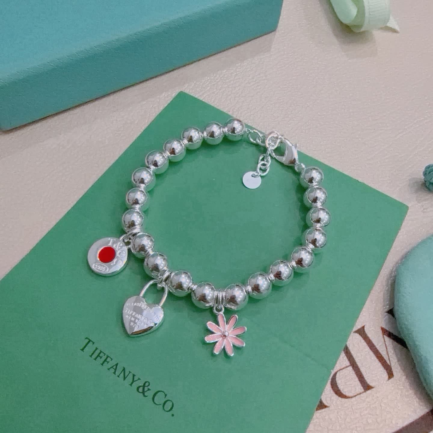 Tiffany & Co. Sterling Silver Bead Bracelet with Lock and Flower Charms